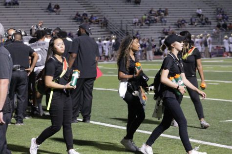 Kaylee Veath and other trainers keep players hydrated during the game. 