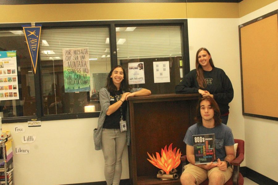 Shawn Parker sits in the library with librarians Kimberly Broomhall and Emily Mirsky. They submitted Parkers poem for the contest. 