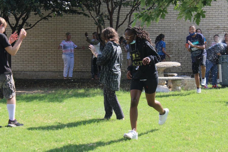 Freshman Atarah Dorsett runs from a water balloon at the event. 