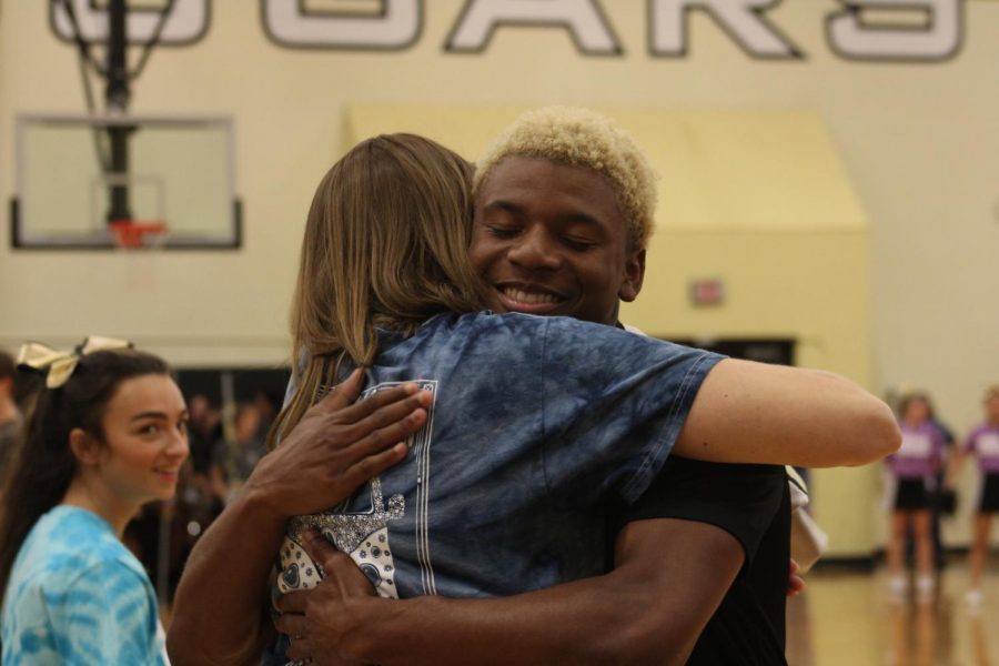 Senior varsity football player Shafiq Taylor hugs U.S. history teacher and Academic Decathlon sponsor Cheryl Chupe. He gave her his jersey at the pep rally. 