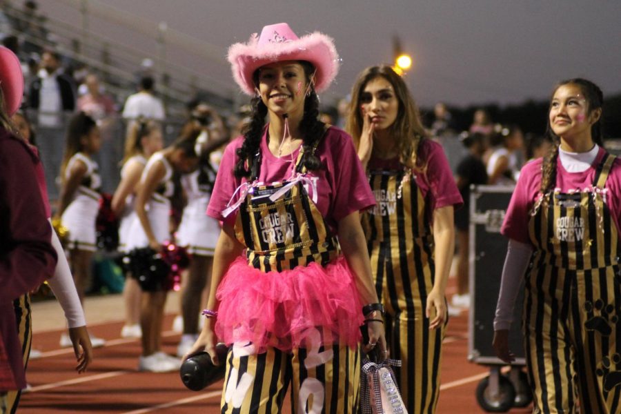 Cougar Crew member Carolina Banda (12) wears all pink with her overalls at the Pink Out game against Heritage.