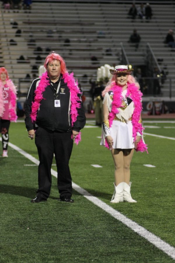 Topcat Officer Holly Snellgrove (12) dances with Principal Dr. Baxter with bright pink boas on during the half time show. 