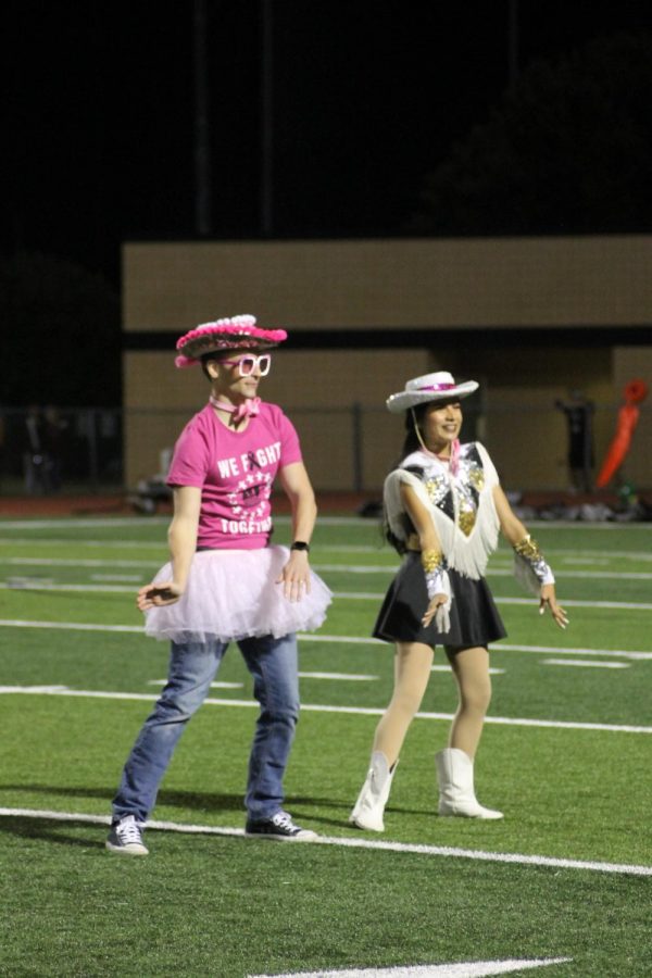 Katelyn Guia (12) dances with assistant principal Bradley Willi during the half time show at the Pink Out game against Heritage. 
