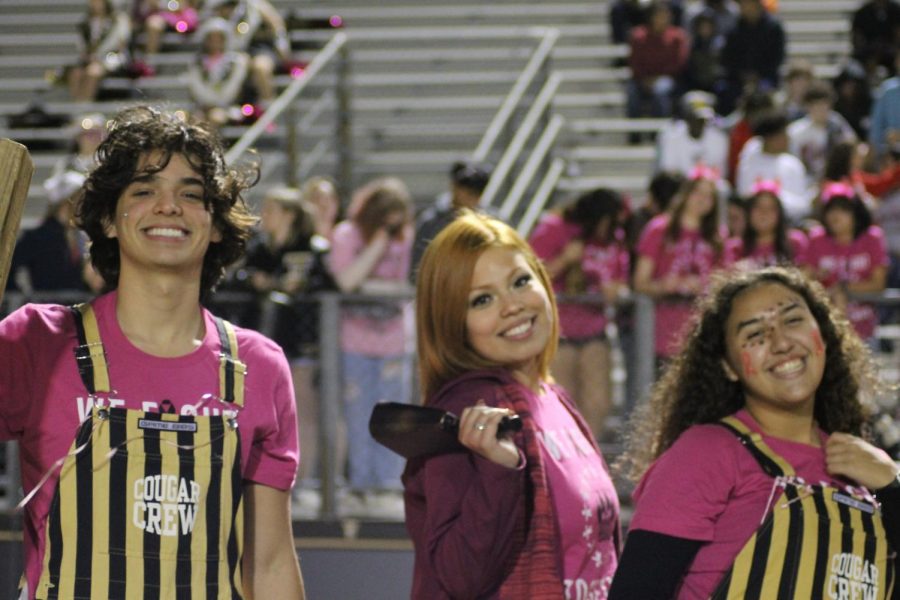 Cougar Crew members smile in pink at the game against Heritage. 