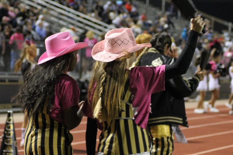 Cougar Crew wears pink cowboy hats and cheers on the football players. 