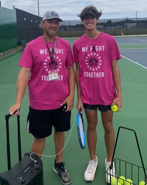 Tennis Head Coach Ryan Turnage and Michael smile in their Pink Out shirts. 