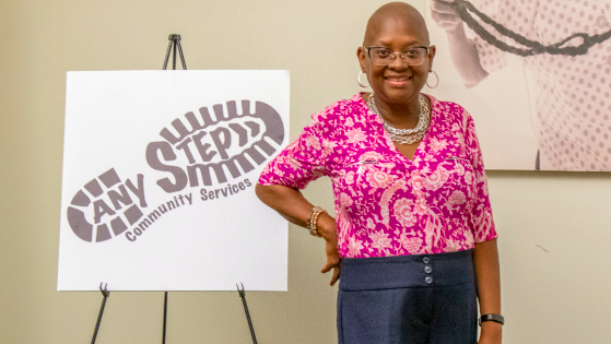 Collegiate Academy’s Professor of Humanities Sydney Portilla-Diggs poses with her organization Any Step sign. 